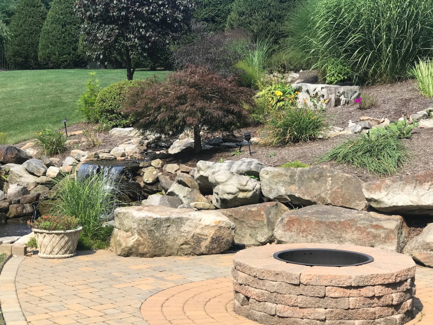 Backyard hardscape and stone waterfall feature