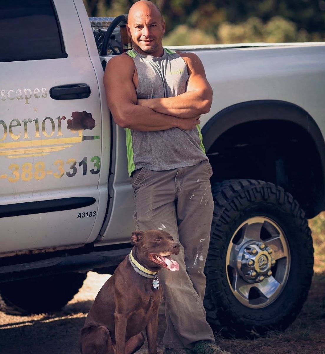 Superior Yardscapes owner Dan with his dog beside a company truck