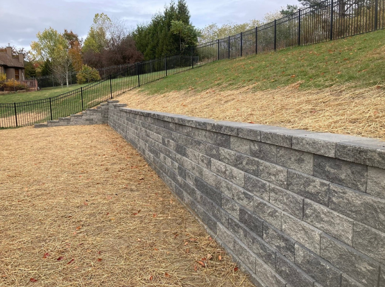 Long block retaining wall holding back a hillside