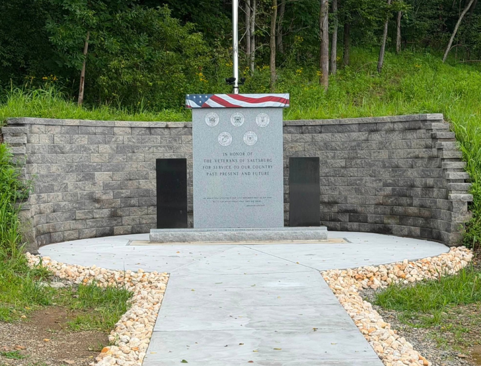 Curved block memorial wall with a paver walkway