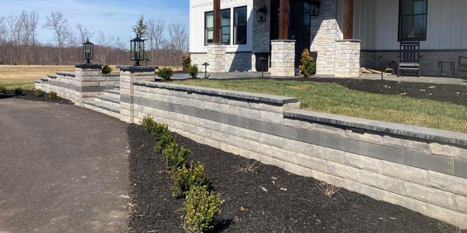 Tiered retaining wall and steps at a home entrance